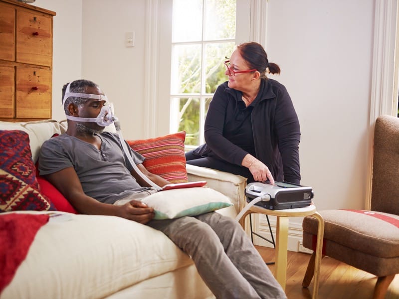 A patient using sleep apnea machine at home with the help of a Whitney Sleep medicine specialist