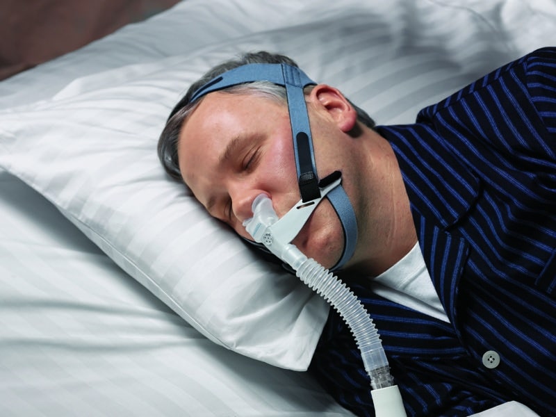 Man uses OptiLife face mask for a good night's sleep. OptiLife facemask is available at the Whitney Sleep in Plymouth, Minnesota