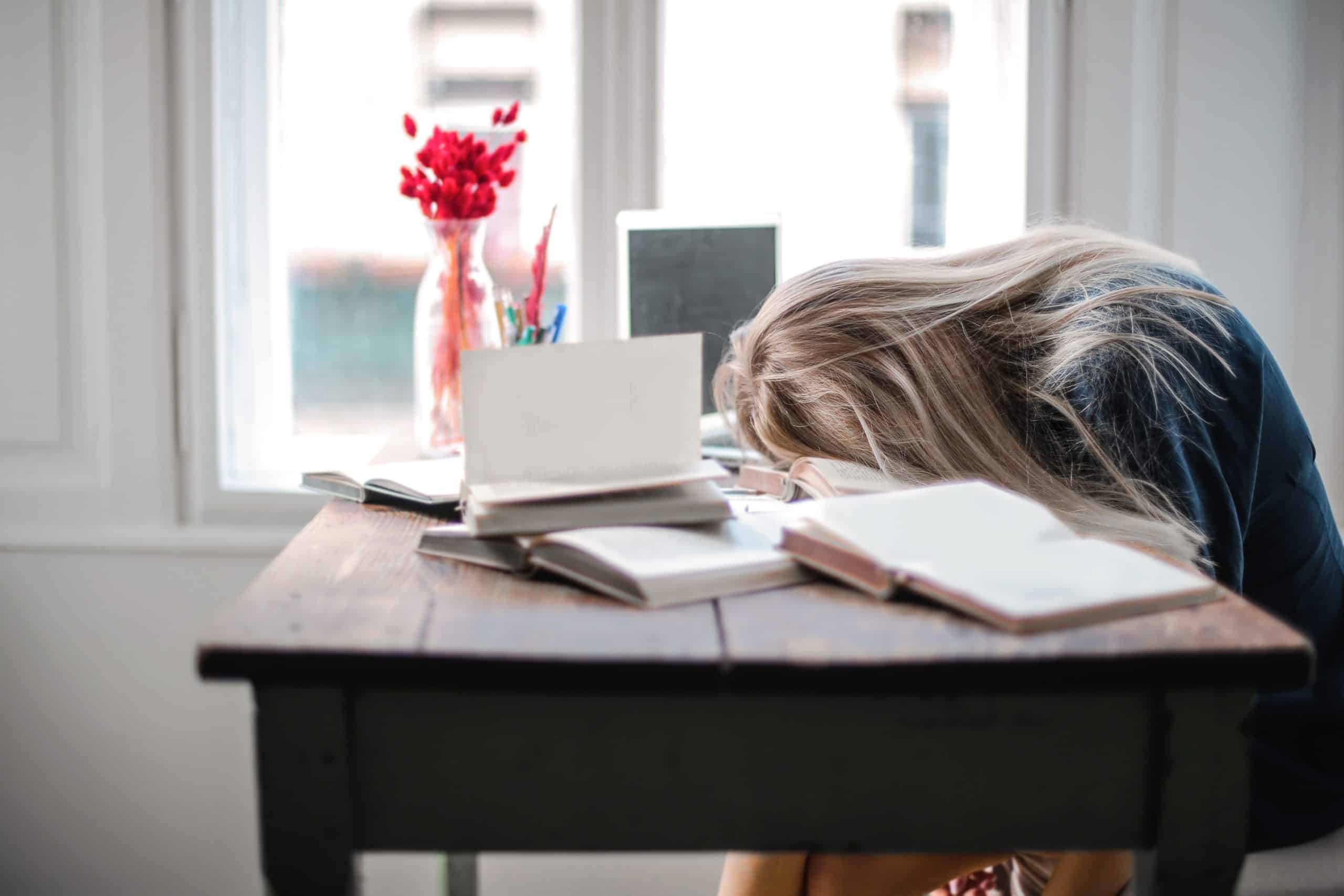 A patient being treated for sleep apnea at Whitney Sleep falls asleep in an awkward position at her desk.