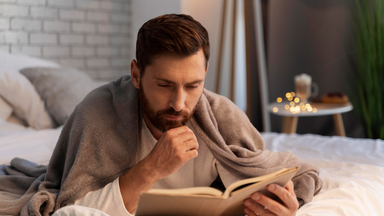 Man reading a book before bed
