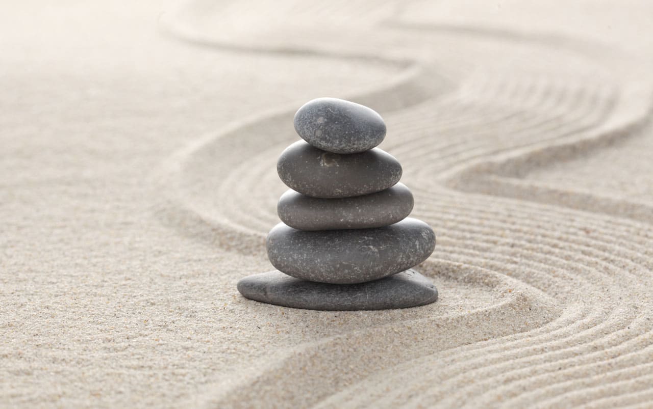 Stacked zen stones on sand ground